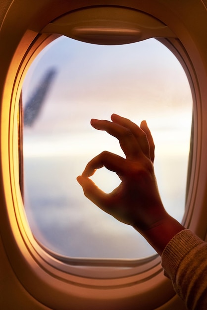 Ce vol se passe très bien Plan d'un passager faisant signe d'accord en regardant par la fenêtre d'un avion