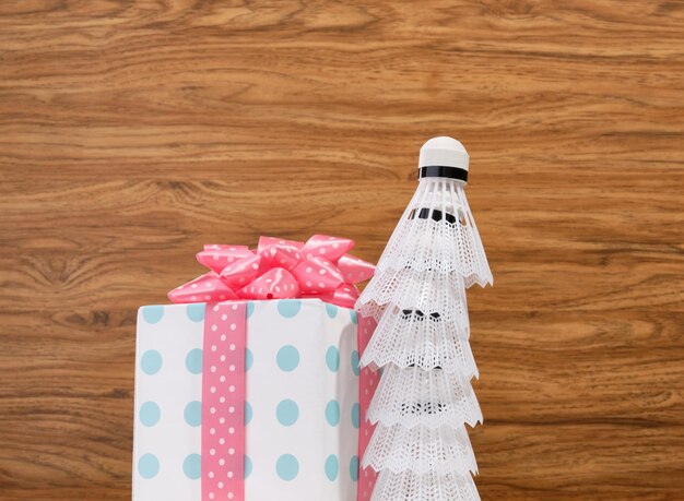 Volants de badminton blancs et belle boîte-cadeau festive sur fond de bois