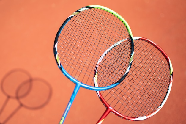 Volants et raquette de badminton sur fond orange.