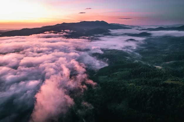 Voler au-dessus du lever du soleil et du brouillard des nuages, sur la colline