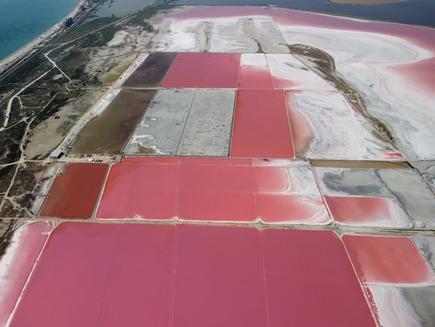 Voler au-dessus d'un lac salé rose installations de production de sel des champs d'étang d'évaporation saline dans le salé