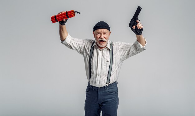 Voleur âgé pose avec de la dynamite et des armes à feu