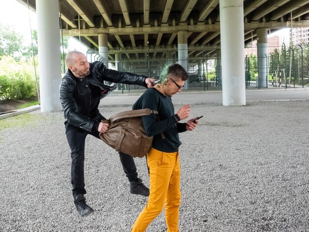 Photo un voleur attaque un homme avec une bouteille.