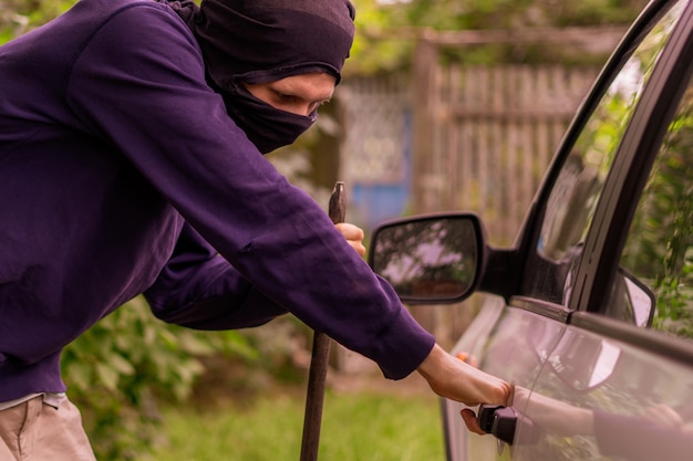 Voleur debout à côté de la voiture et essayant de voler des choses