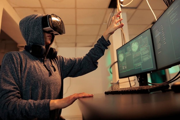 Voleur piratant la base de données dans le métaverse et codant des logiciels espions avec des lunettes vr la nuit, volant des informations électroniques. Cyberattaque faite sur le système gouvernemental, malware informatique de réalité virtuelle.