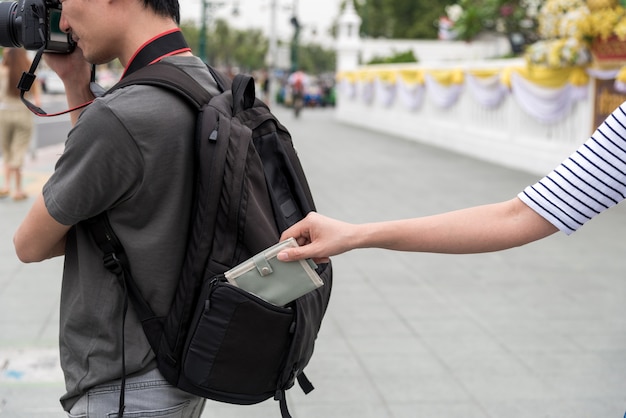 voleur voler une poche d&#39;argent de sac à dos touristique