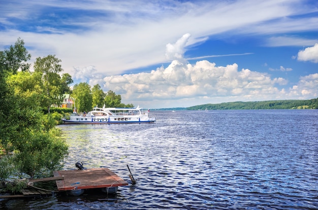 La Volga dans la ville de Plyos et un bateau blanc près du rivage sous un ciel d'été avec des nuages