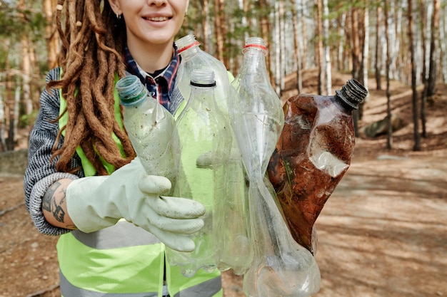 Volontaire montrant des bouteilles en plastique