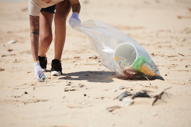 Volontaire nettoyant la plage du plastique