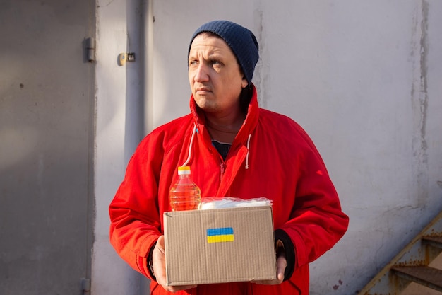 Volontaire préparant une boîte de nourriture pour les réfugiés de guerre ukrainiens concept d'aide et d'aide humanitaire