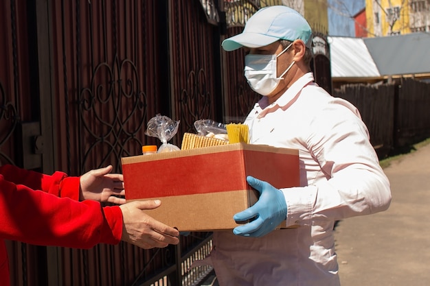 Le volontaire remet une boîte de nourriture à ceux qui en ont besoin