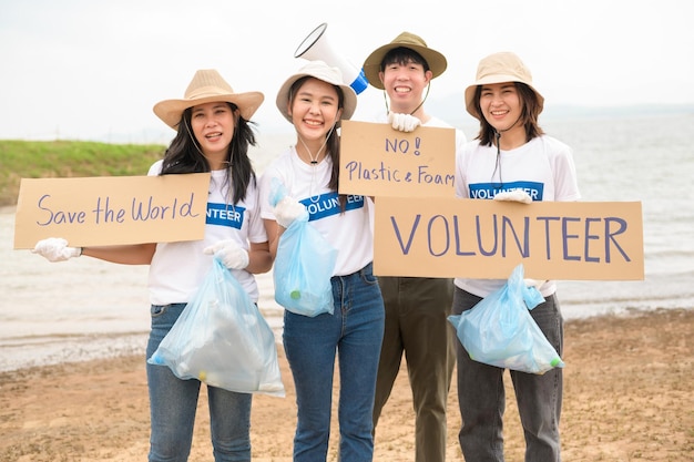 Des volontaires de la communauté des jeunes asiatiques utilisent des sacs poubelles pour nettoyer la nature par