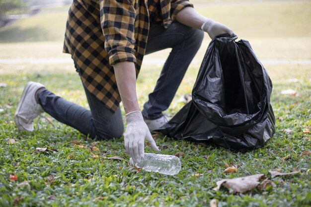 Des volontaires portent des bouteilles d'eau ou des sacs en plastique qui sont tombés dans le parc et les mettent à la poubelle.