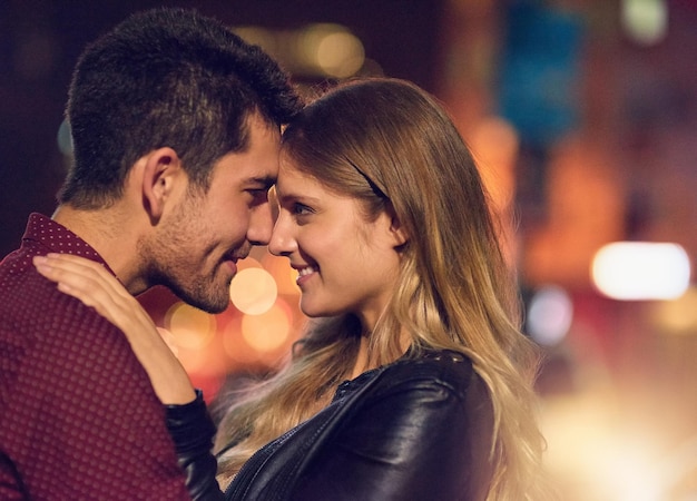 Photo votre bonheur est mon bonheur photo d'un jeune couple heureux partageant un moment romantique ensemble dehors la nuit