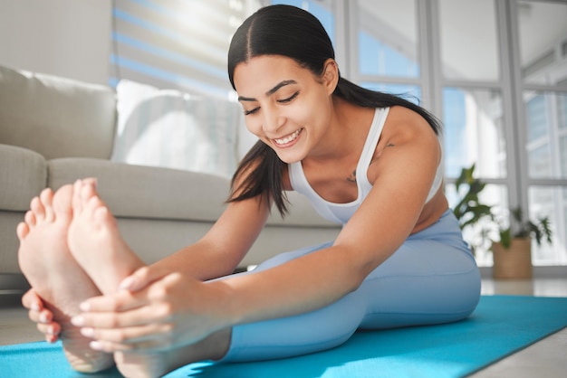 Votre parcours de remise en forme est tout aussi important que le résultat. Photo d'une jeune femme sportive qui s'étire tout en faisant de l'exercice à la maison.