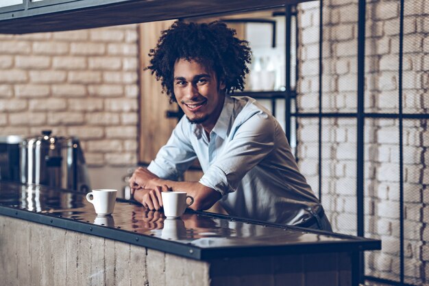 Photo vous avez du café ? jeune homme africain regardant la caméra avec le sourire