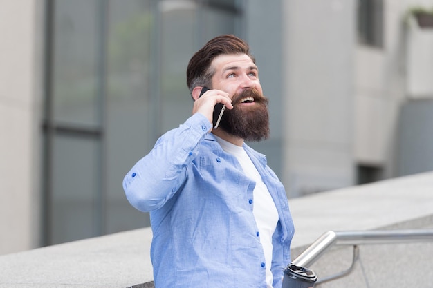 Vous m'entendez. Un homme barbu utilise un smartphone à l'extérieur. Technologie mobile. Nouvelle technologie. Technologie cellulaire. Vie moderne. Technologie pour la communication.