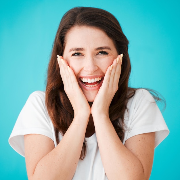 Vous ne devriez pas avoir Portrait en studio d'une jolie jeune femme qui a l'air surprise sur un fond bleu