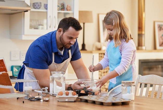 Vous pouvez le faire Photo d'un jeune homme aidant sa fille à remuer un bol de mélange à gâteau