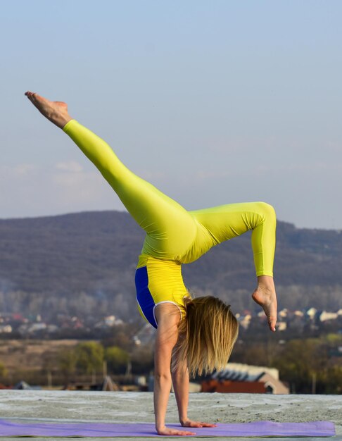 Vous venez de devenir fort Gymnastique acrobatique Athlète de gymnastique Cela n'a jamais été aussi facile Fille flexible en plein air Femme pratiquant le yoga Étirement des muscles Entraîneur de fitness Femme accomplit des exploits de gymnastique