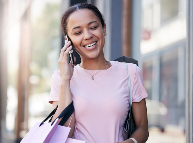 Voyage d'appel téléphonique ou femme noire avec des sacs à provisions dans la ville de Paris ou sur la route pour les réseaux de communication ou parler en plein air Sourire heureux ou fille voyageant avec un smartphone pour des nouvelles comiques