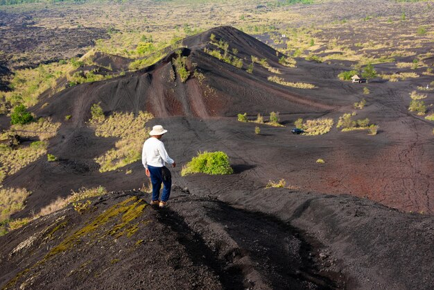 Photo voyage au volcan batur à bali indonésie sable de lave noire et plantes vertes