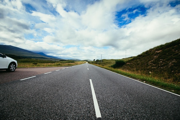 Voyage ou aventure Route dramatique abandonnée dans le ciel nuageux de l'Ecosse