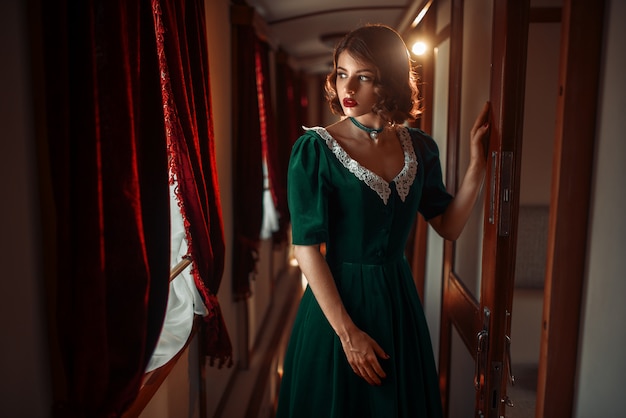 Voyage en chemin de fer, femme en train rétro, intérieur riche. Vieux wagon. Voyage ferroviaire