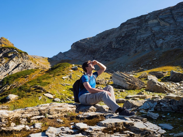 Un voyage dans les montagnes un jeune homme avec un sac à dos se promène seul dans les montagnes nature et mou...