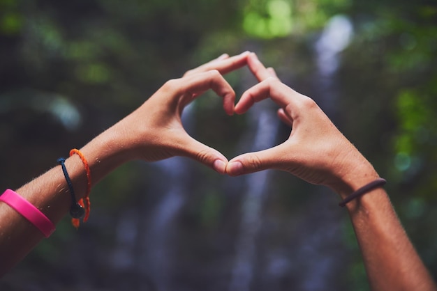 Le voyage est son véritable amour Photo d'une jeune femme non identifiable faisant un geste du cœur avec ses mains dans la jungle