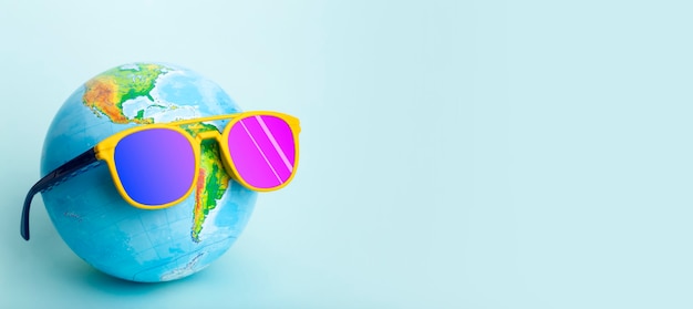 Voyage été concept globe dans des lunettes de soleil sur fond coloré soleil vacances et tourisme idée créative photo de haute qualité