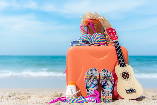 Photo voyage d'été avec vieille valise et maillot de bain femme fashion bikini, étoile de mer, lunettes de soleil, chapeau. voyage en vacances, fond de plage coucher de soleil. concept d'été et de voyage.