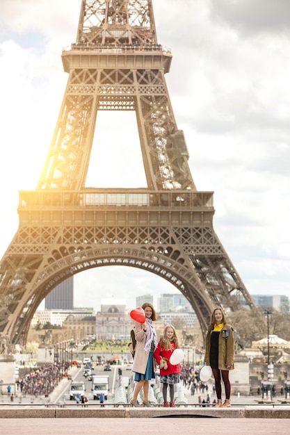 Voyage en famille. Maman et filles heureuses sur le fond de la Tour Eiffel à Paris. La France