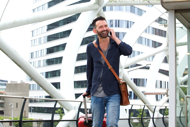 Voyage homme marchant avec valise et parler au téléphone mobile