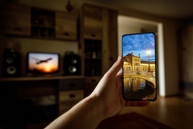 Voyage en ligne à Séville, en Espagne, depuis la maison en utilisant un téléphone portable. Plaza de Espana sur l'écran du smartphone