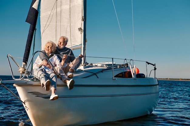 Voyage en mer heureux beau couple de personnes âgées s'embrassant et s'amusant tout en se relaxant sur un voilier