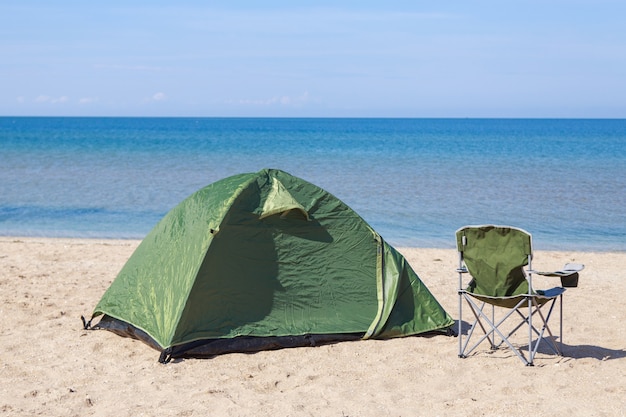 Voyage à la mer. tente et chaise de camping sur la plage.