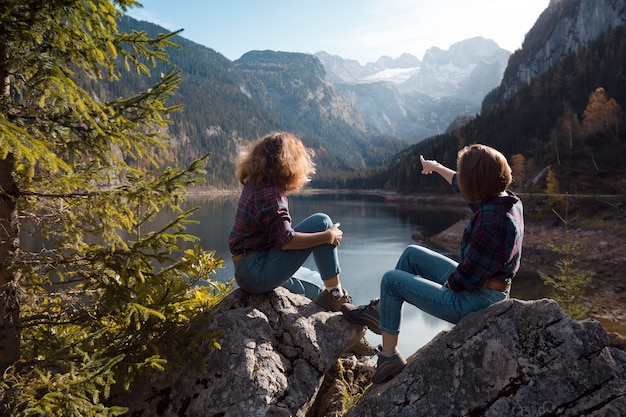 Voyage en montagne. deux filles heureuses sur le fond d'un lac de montagne et des montagnes en arrière-plan