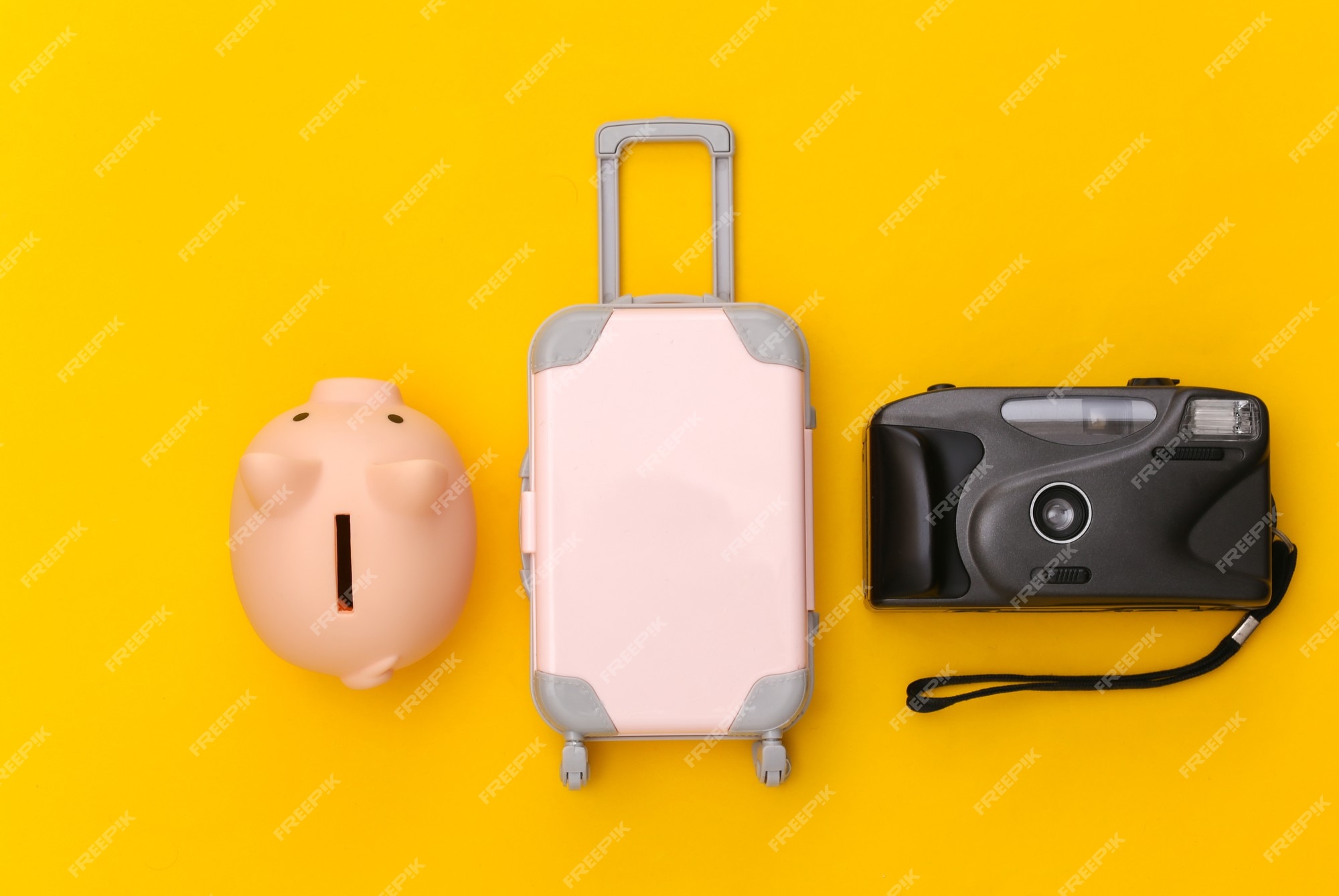 https://img.freepik.com/photos-premium/voyage-plat-mini-valise-voyage-plastique-tirelire-appareil-photo-fond-jaune-style-minimaliste-vue-dessus_175682-23428.jpg?w=2000