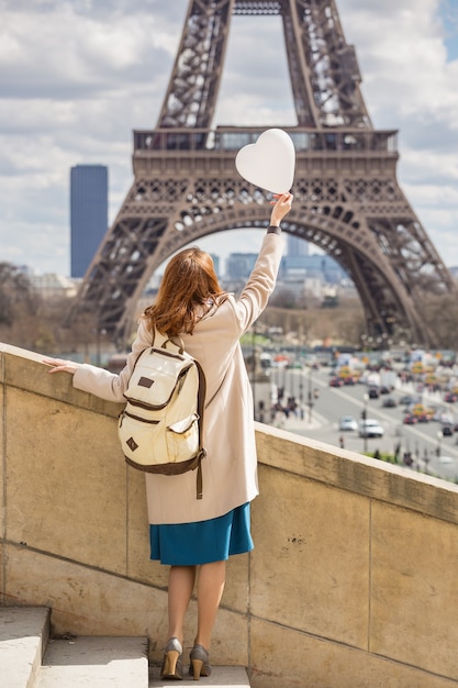 Voyage à travers l'Europe. fille avec un ballon en forme de coeursur le fond de la Tour Eiffel à Paris. La France