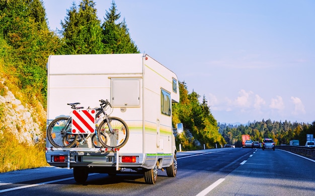 Voyage de vacances avec Caravan Car avec vélo sur route, Suisse. Camping-car et été en voiture sur l'autoroute. Voyage de vacances en camping-car rv pour les loisirs. Balade en camping-car dans la nature. Paysage.