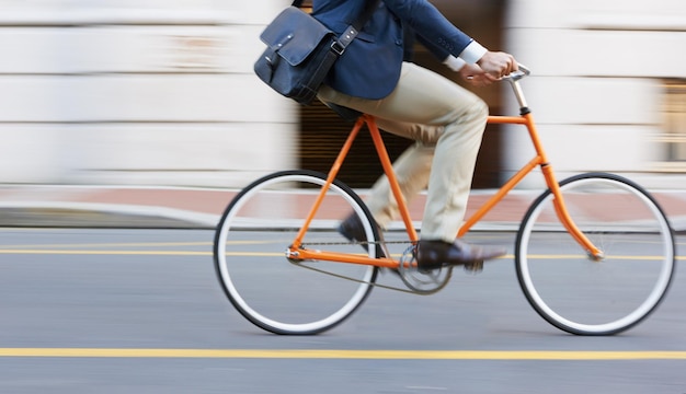 Voyage à vélo et jambes d'un homme d'affaires sur une route pour se rendre au travail ou à un rendez-vous dans la rue na Empreinte carbone du vélo et des chaussures d'un homme à vélo voyageant dans une ville en transport respectueux de l'environnement