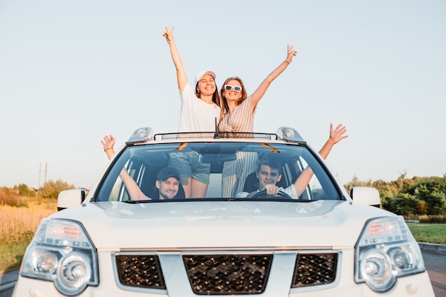 Voyage en voiture. des gens heureux et amusants mettent du toit ouvrant. voyage en voiture