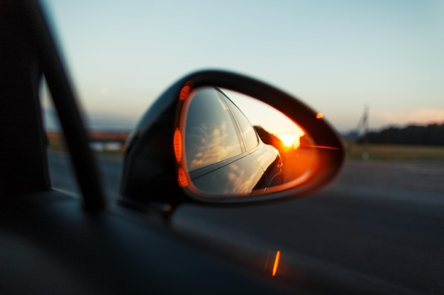 Voyager en voiture avec un coucher de soleil dans le miroir