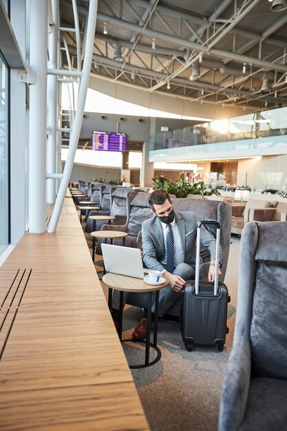 Voyageur dans un masque d'hôpital défaisant ses bagages