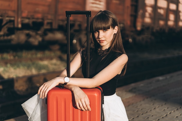 Voyageur femelle avec valise rouge train en attente sur la gare