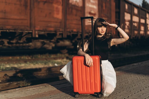 Voyageur femelle avec valise rouge train en attente sur la gare