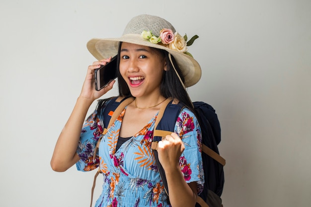 Voyageur femme asiatique parlant au téléphone mobile. concept de voyage d'été sur fond blanc