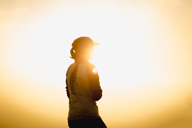 Voyageur de femme au coucher du soleil ou au lever du soleil atteint le sommet de la montagne au cours de hiki