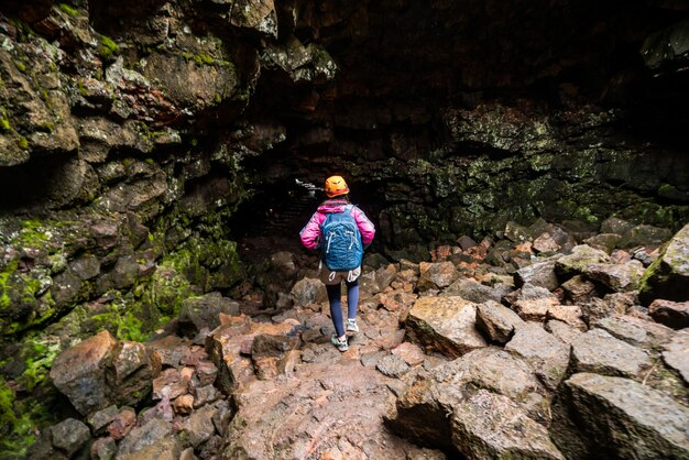 Voyageur femme explorer le tunnel de lave en Islande.